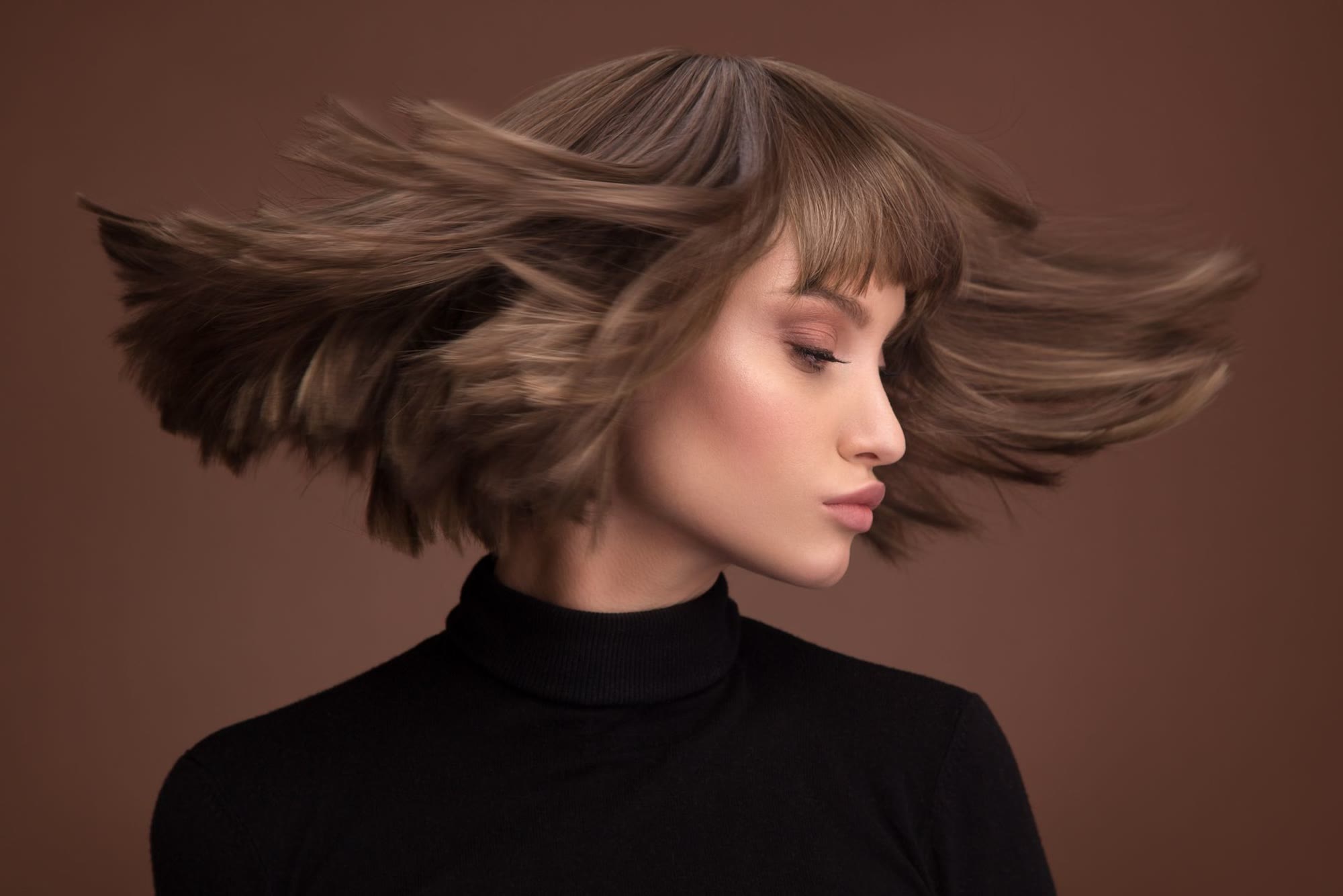 Layered brunette bob caught mid hair-flip — cut and color by Hair Rocks @Artisans, Boynton Beach